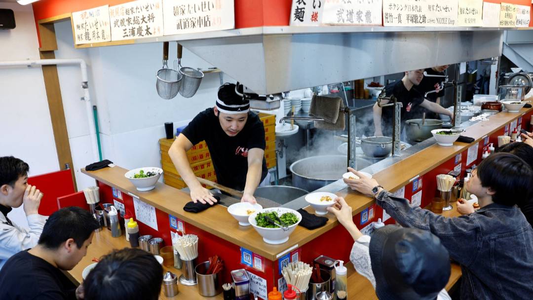 2024年10月22日，日本東京拉麵店「麵家泰星」店員正為客人送餐。路透社